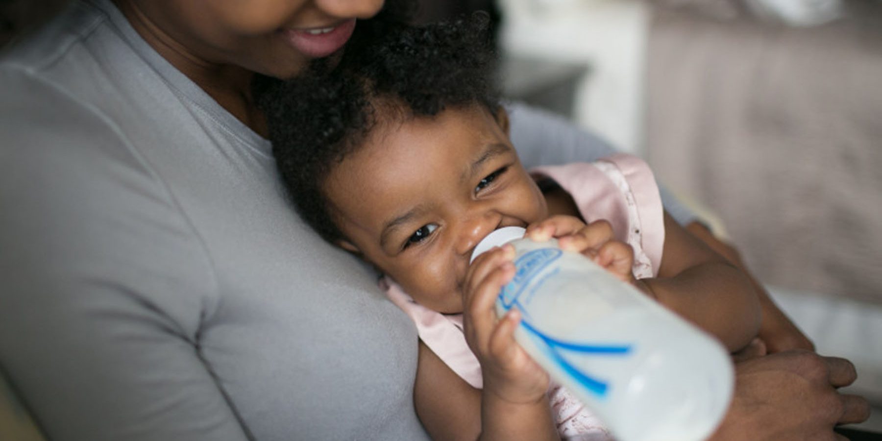 baby holding bottle and drinking